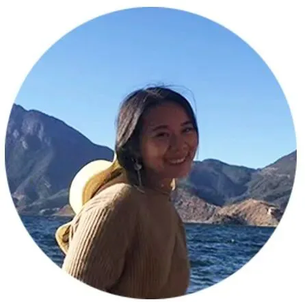 张亮亮的圆形头像照,她面带微笑,身穿棕色毛衣,背景是湖泊与山脉。