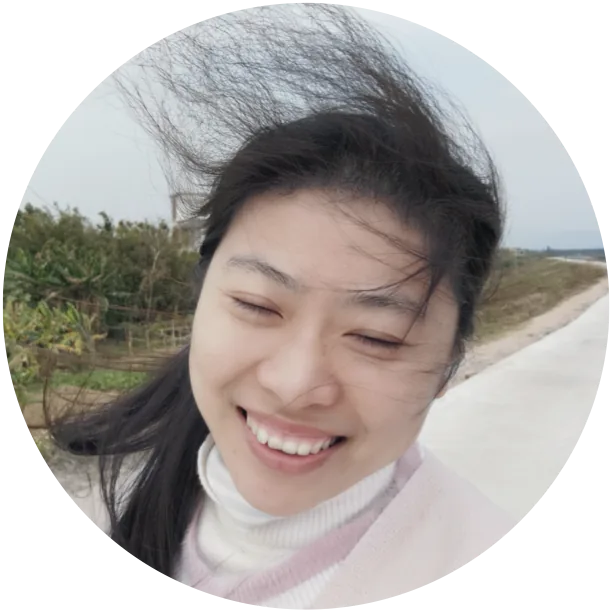 安超在户外的笑脸自拍圆形头像,身后是乡间小路与农田,长发被风吹起。
