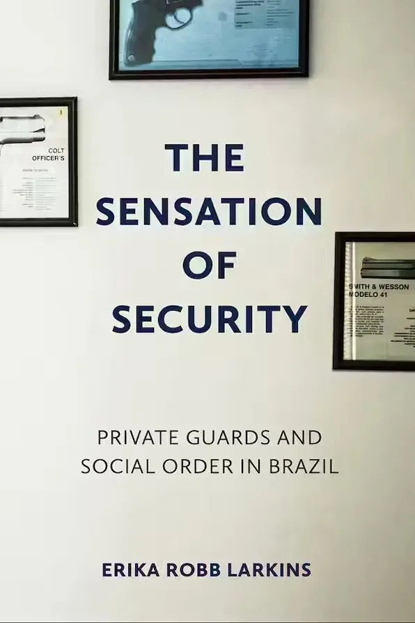 《安全感》(The Sensation of Security)封面,白墙上挂着几幅装裱的手枪展示图片,如柯尔特和史密斯威森型号说明牌。作者艾瑞卡·罗伯·拉金斯。