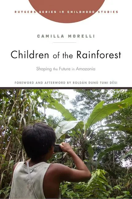 《雨林之子》(Children of the Rainforest)封面,下方照片是一名儿童背对镜头,举起手中的物件对着雨林中的阔叶植物拍摄。作者卡米拉·莫雷利。