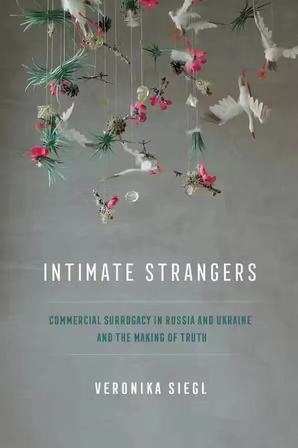 书封《Intimate Strangers: Commercial Surrogacy in Russia and Ukraine and the Making of Truth》,作者 Veronika Siegl;灰色背景上悬挂着白色羽毛、粉红花朵与松枝编成的吊饰。