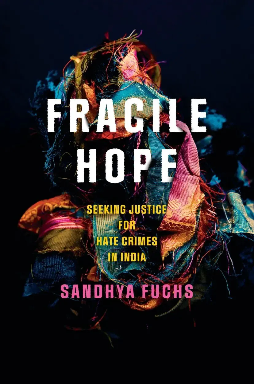 书封《Fragile Hope: Seeking Justice for Hate Crimes in India》,作者 Sandhya Fuchs;黑色背景中一团色彩斑斓、缠绕纠结的碎布与丝线。