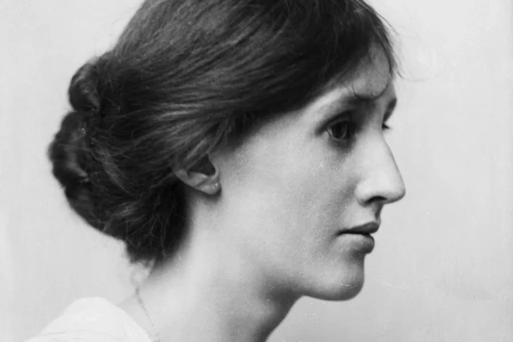 Virginia Woolf黑白侧面肖像照,她发髻低盘,望向画面右侧。