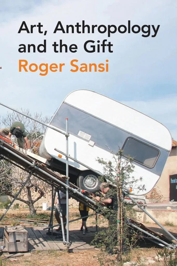 书封《Art, Anthropology and the Gift》,作者Roger Sansi,照片中一辆房车被架在金属斜坡装置上高高翘起,像是被发射升空,几名工作人员在旁边操作,背景是户外空地和树木。