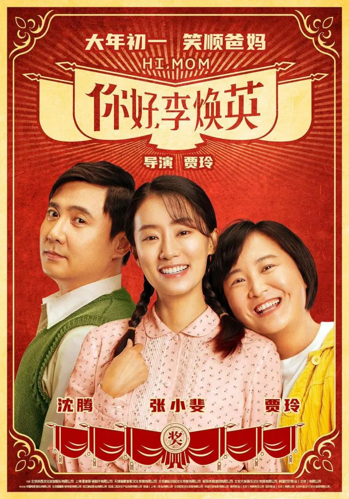 电影《你好,李焕英》海报,红色喜庆风格,沈腾、张小斐、贾玲三位主演并排微笑,上方写有“大年初一笑顺爸妈”及导演贾玲字样。