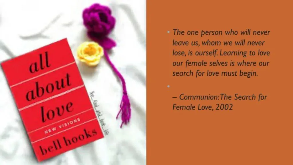 课件页,左侧是《All About Love》封面照片,旁边放着紫色和黄色的钩织花朵;右侧引用原文:“The one person who will never leave us, whom we will never lose, is ourself. Learning to love our female selves is where our search for love must begin.”(出自Communion: The Search for Female Love, 2002)