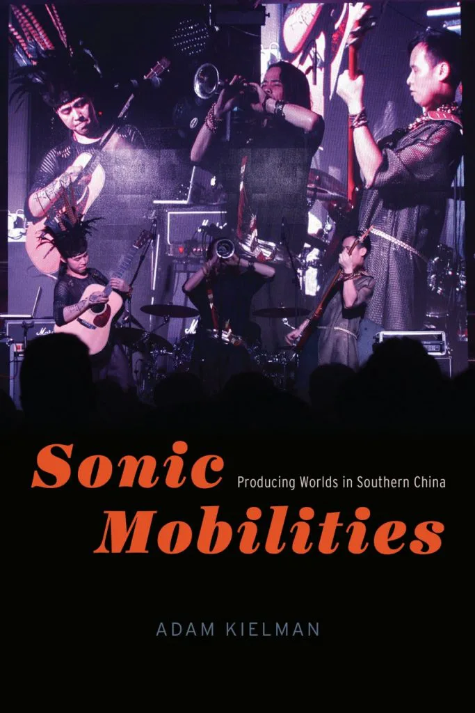 书封《Sonic Mobilities: Producing Worlds in Southern China》(声波流动),作者亚当·乔曼,封面是一支乐队在舞台上演出的照片,一名乐手戴着羽饰头饰。