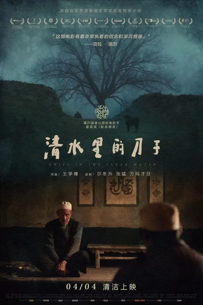 电影《清水里的刀子》海报,上方是枯树剪影和获奖信息,下方两位戴白帽的男子跪坐在土墙庭院中,注明改编自石舒清同名小说