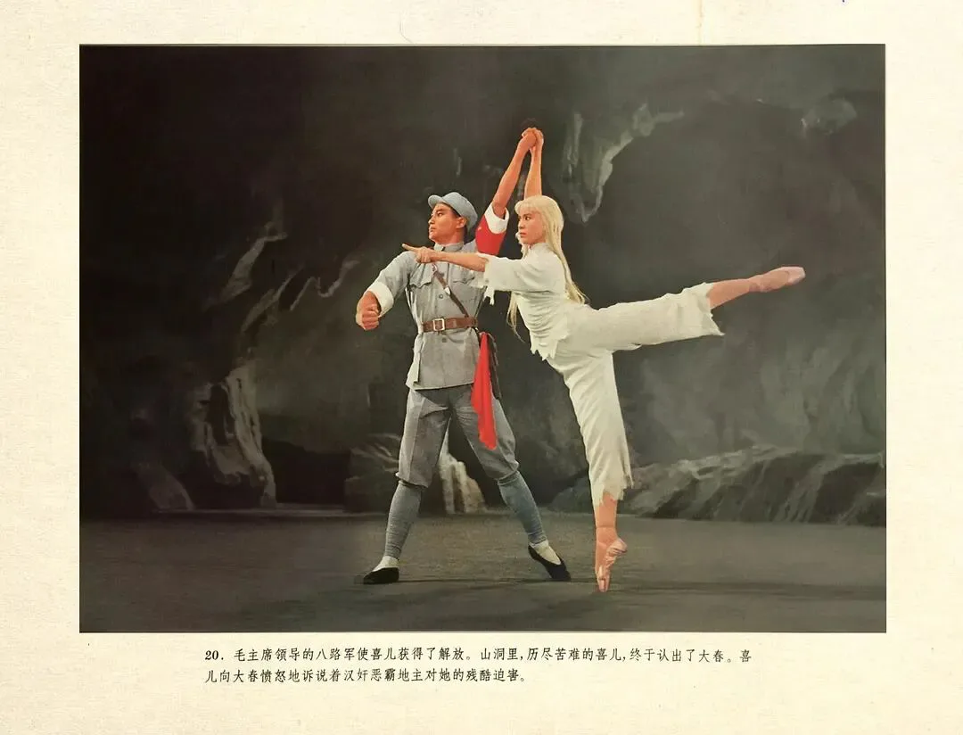 彩色剧照,男舞者身着灰色军装伸手指向前方,女舞者身着白色芭蕾服单腿立起、双臂上举,背景是山洞布景;图片下方印有说明文字,讲述喜儿向大春控诉恶霸迫害的情节。
